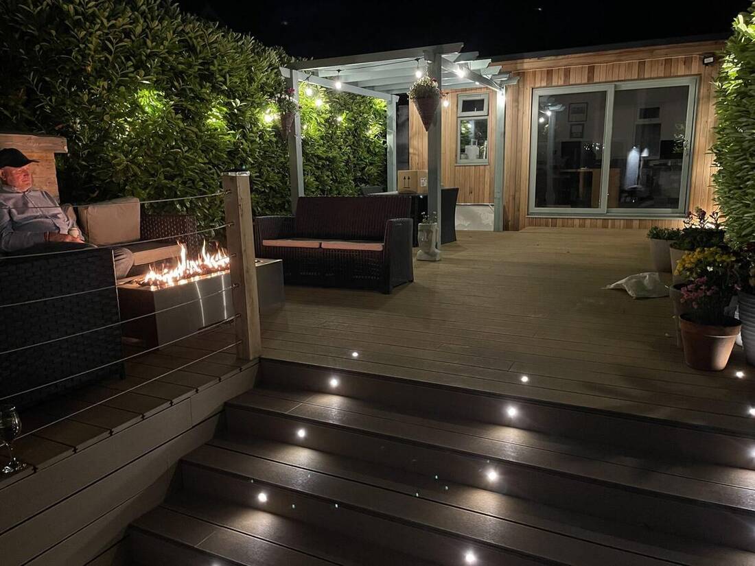 Garden room and deck lit at night